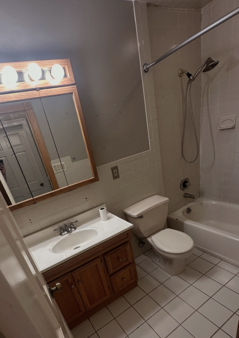 Old oak vanity and light bar before bathroom remodel in Parlin, NJ