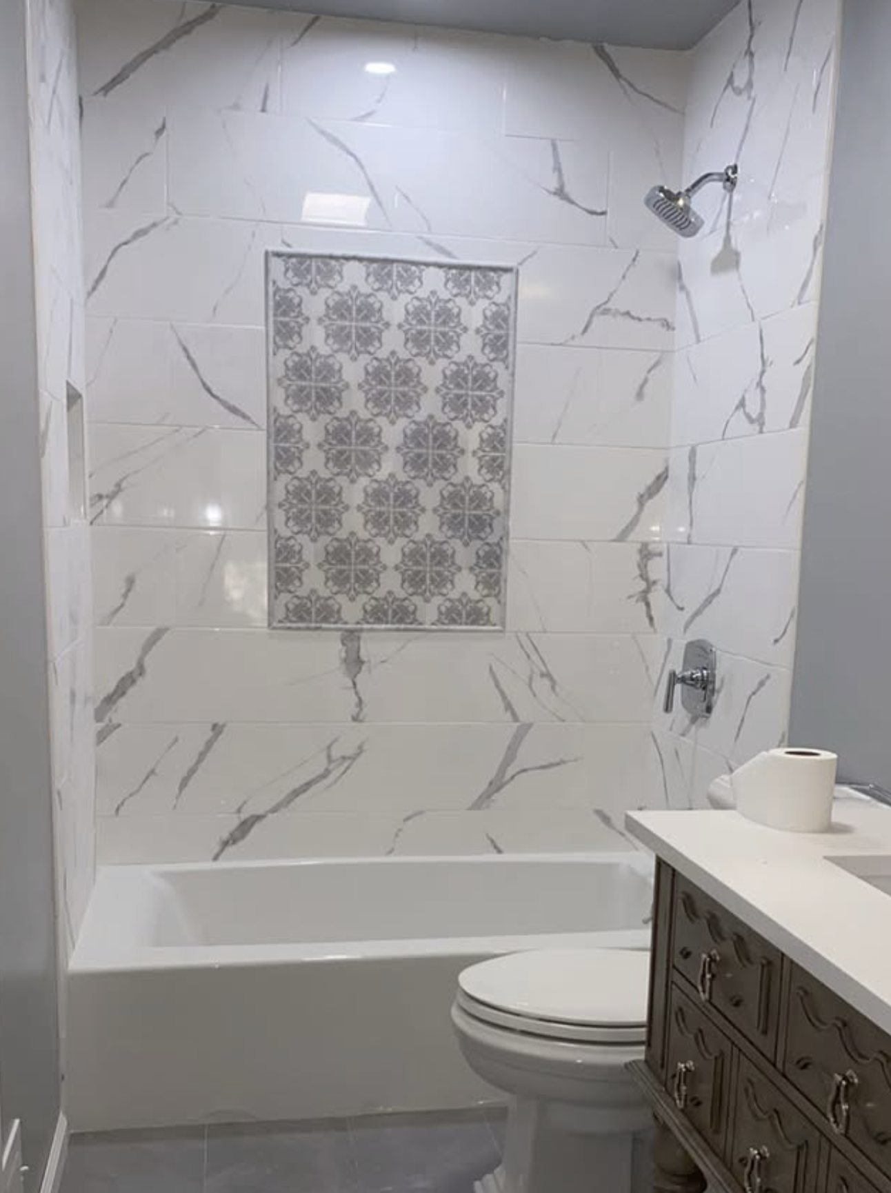 Tub surround with patterned niche by Zollinger Construction in Cheesequake, NJ